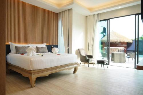 a bedroom with a large bed and a living room at Phattrasom Villa in Cha Am