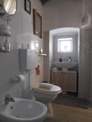 a bathroom with a white toilet and a sink at La Casa di Anna'80 in SantʼArcangelo