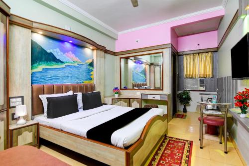 a bedroom with a bed with a painting on the wall at Hotel Shree Krishna in Keonjhargarh