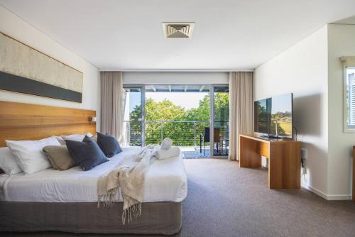 a bedroom with a large bed and a television at 3BR Golfside Villa | Pools, Tennis & Relaxation in Magenta