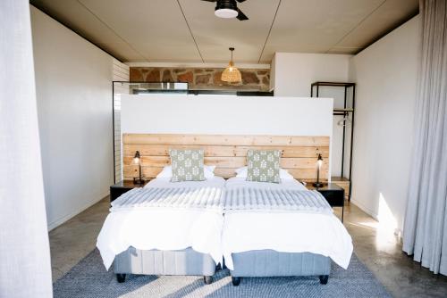 a bedroom with a large bed with a large headboard at Oudeberg Living- Oudeberg Lodge in Sutherland