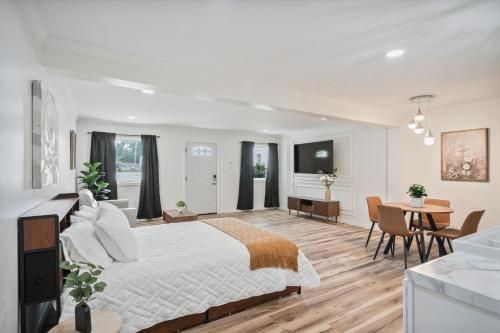 a white bedroom with a large bed and a table at Cashmere Private Studio Cozy Chic Escape in Kokomo