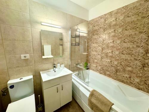 a bathroom with a sink and a tub and a toilet at The Nest in Otopeni