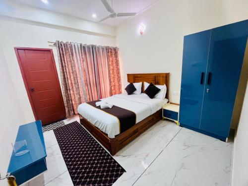a bedroom with a bed and a red door at Selfie Residency in Mysore