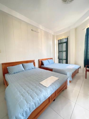 a bedroom with two beds and a window at ANH VAN Motel in Chau Doc