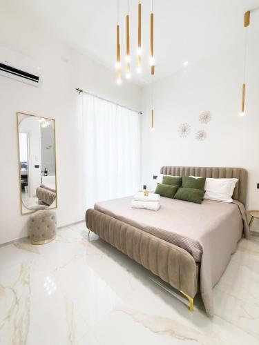 a bedroom with a large bed and a mirror at Bosa Centro Rooms in Bosa