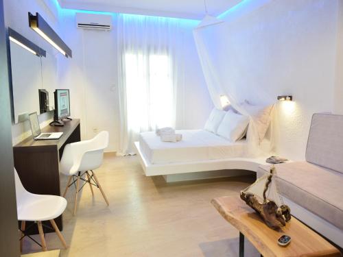 a white room with a bed and a desk and chairs at Afytos Lofts in Afitos