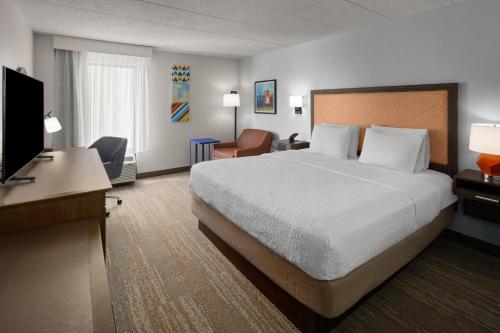 a hotel room with a bed and a desk and a television at Hampton Inn Dover in Dover