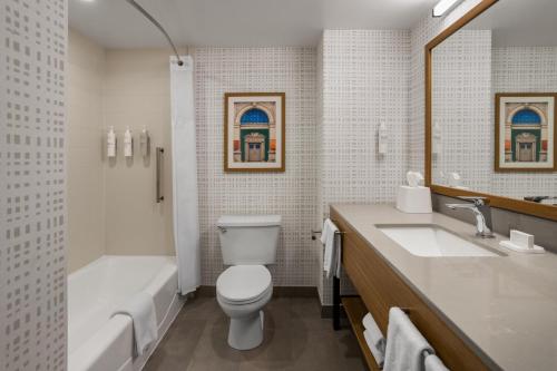 a bathroom with a toilet and a sink and a tub at Hampton Inn Staunton in Staunton