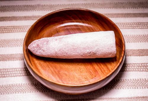 a wooden plate with a piece of food on a table at Sumaj Casa Hotel in Tarapoto