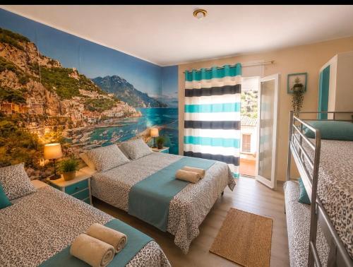 a bedroom with two beds and a mountain mural at Emporda Llanca Guesthouse in Llança