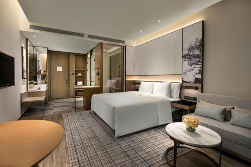 a hotel room with a bed and a couch at Wanda JIN Baise in Qitang