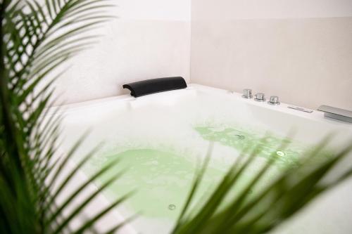 a bath tub with a black chair in a bathroom at Bosa Centro Rooms in Bosa