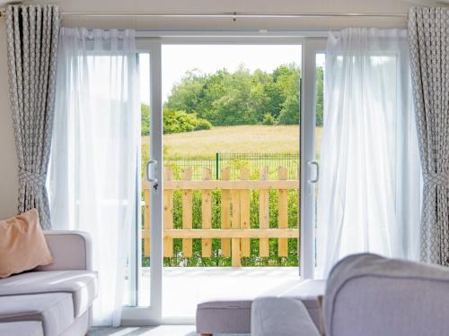 a living room with a sliding glass door to a balcony at Nova - Ukc9932 in Aston