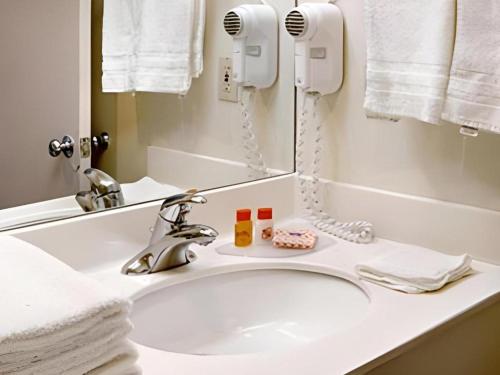 a bathroom sink with a mirror and a phone at Shalimar Hostel in Las Vegas