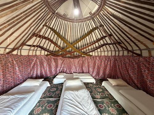 a room with two beds in a yurt at Besqala Yurt Camp in Kabanbay