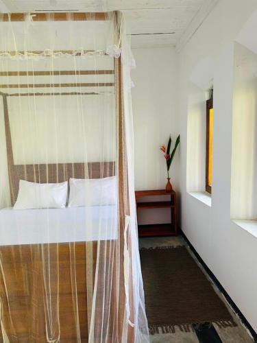 a bedroom with a bed with a mosquito net at La Olive Villa 