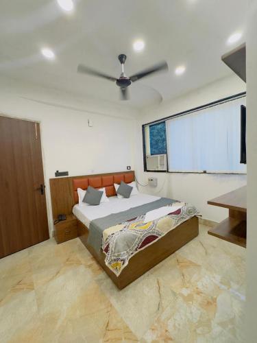 a bedroom with a bed and a ceiling fan at Hotel Shankara Inn in Ayodhya