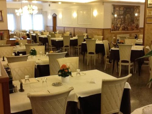 ein Esszimmer mit weißen Tischen und weißen Stühlen in der Unterkunft Hotel Belfiore in Salzano