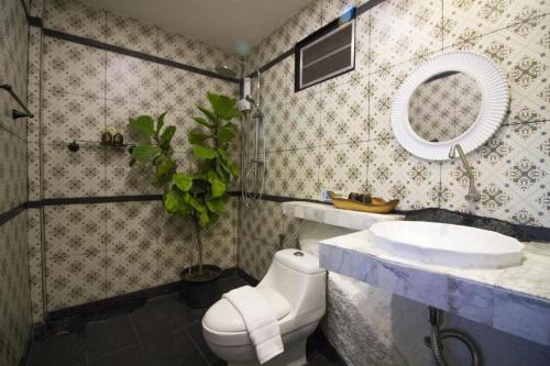 a bathroom with a sink and a toilet and a mirror at Tanote Good View in Ko Tao