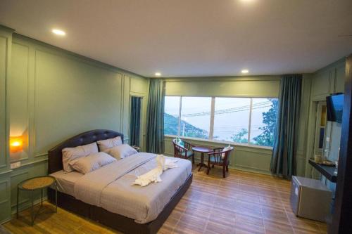a bedroom with a bed and a table and a window at Tanote Good View in Ko Tao