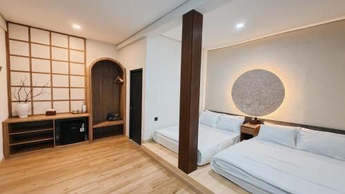 a hotel room with two beds and a mirror at Asthaloka Bed & Chill Pasteur in Bandung