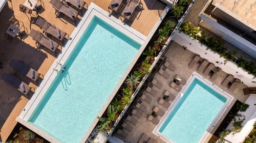 an overhead view of two swimming pools on a building at Enorme Epavli Urban Living in Hersonissos