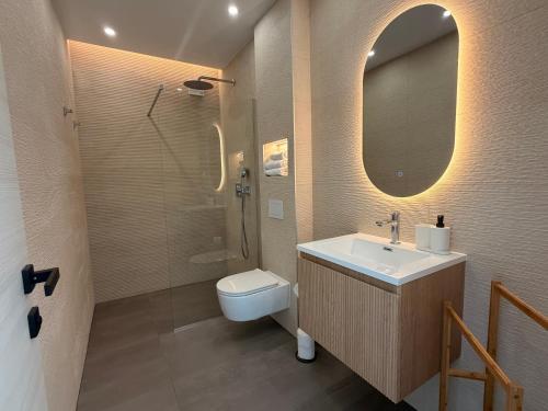 a bathroom with a sink and a toilet and a mirror at Apartments Soho in Trogir