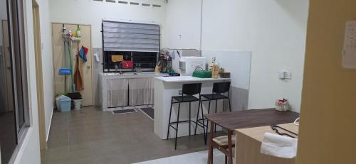 a kitchen with a counter and a stove top oven at Rumah Inap Nik Atik in Cukai