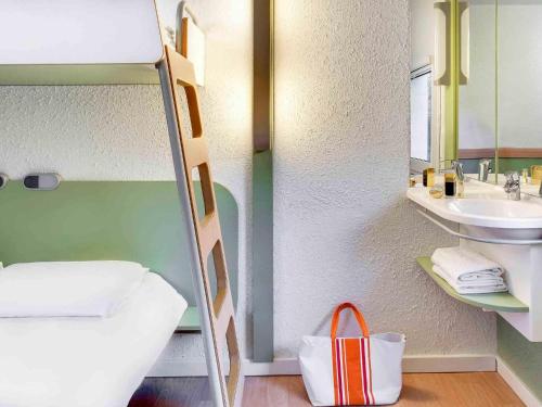 a small bathroom with a sink and a mirror at Hotel Ibis Budget Vichy in Bellerive-sur-Allier