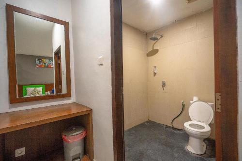 a bathroom with a toilet and a mirror at Melati Kuta Lombok in Kuta Lombok