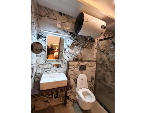 a bathroom with a toilet and a sink at Velour Pines Pahalgam in Pahalgām