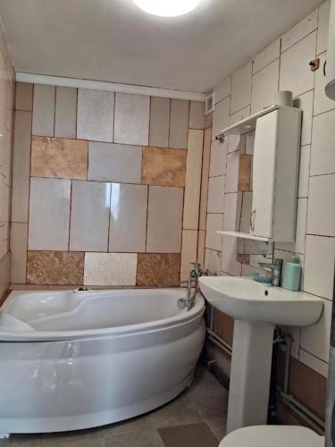 a bathroom with a tub and a sink next to a bath tub at Закоханий у море in Odesa