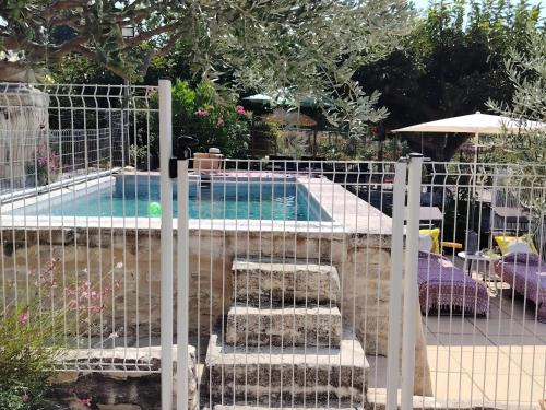 a fence with stairs next to a swimming pool at Gîte Lavande - Le Jardin Secret du Ventoux in Modène