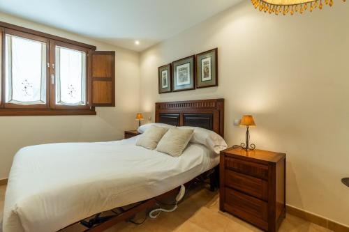 a bedroom with a bed and a nightstand and two windows at Casa PETRONILA in Lerma