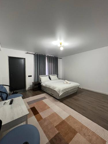 a bedroom with a bed and a table and chairs at Bon Hostel Kg in Bishkek