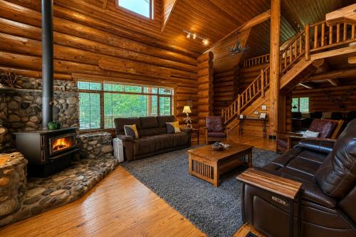 a living room with a fireplace in a log cabin at Soaring Pines Lodge by NW Comfy Cabins in Leavenworth