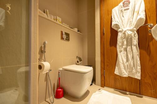 a bathroom with a white toilet and a shower at Pearl 1BR Al Reem - Serene Luxe Escape in Abu Dhabi