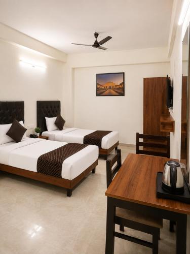 a hotel room with two beds and a table at Hotel Elite Stay in Bori