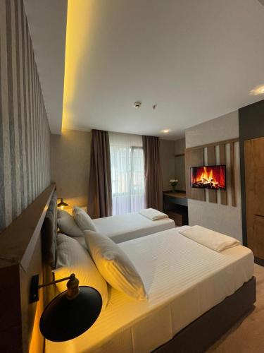 two beds in a hotel room with a fireplace at Dedehan Hotel in Trabzon
