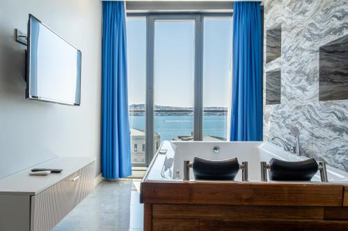 a bathroom with a tub with blue curtains at Elite World Homes Istanbul Bosphorus in Istanbul
