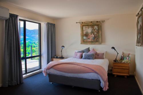 a bedroom with a bed and a large window at New Norfolk Holiday Apartments in New Norfolk