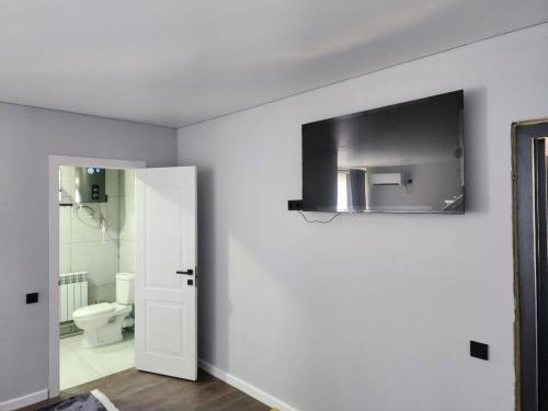 a white bathroom with a toilet and a sink at Bon Hostel Kg in Bishkek