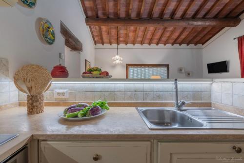 a kitchen with a sink and a bowl of fruit on the counter at Il Lebbio Agriresort in Montaione
