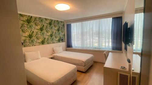 ein Hotelzimmer mit zwei Betten und einem Fenster in der Unterkunft Walkin Hotel in Konak