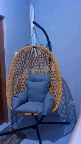 a wicker chair with a blue pillow in a room at The Mason Hideout in Watamu