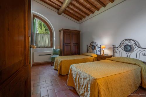 a hotel room with two beds and a window at Il Lebbio Agriresort in Montaione