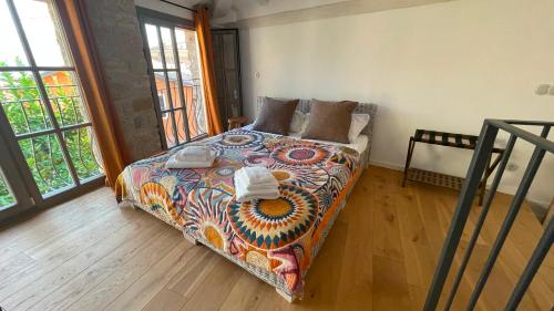 a bedroom with a bed with a colorful comforter at Casa Limone - a due passi dal lago in Castelletto di Brenzone