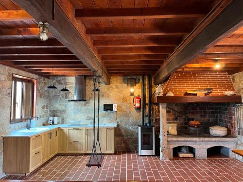a kitchen with a stove and a brick oven at O Rincón de David in Cee