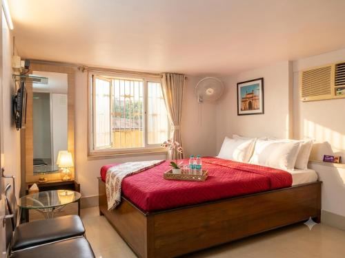 a bedroom with a large bed with a red blanket at Lake Land Guest House in Kolkata